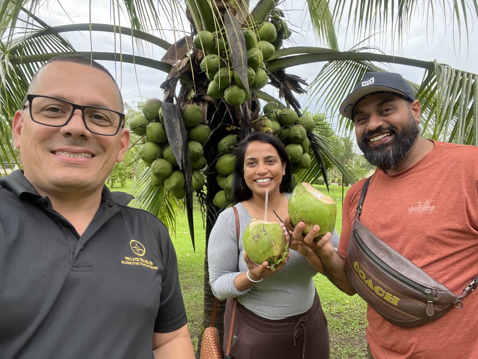 Diego in his Private Travel CR polo with travelers enjoying fresh coconuts in Costa Rica